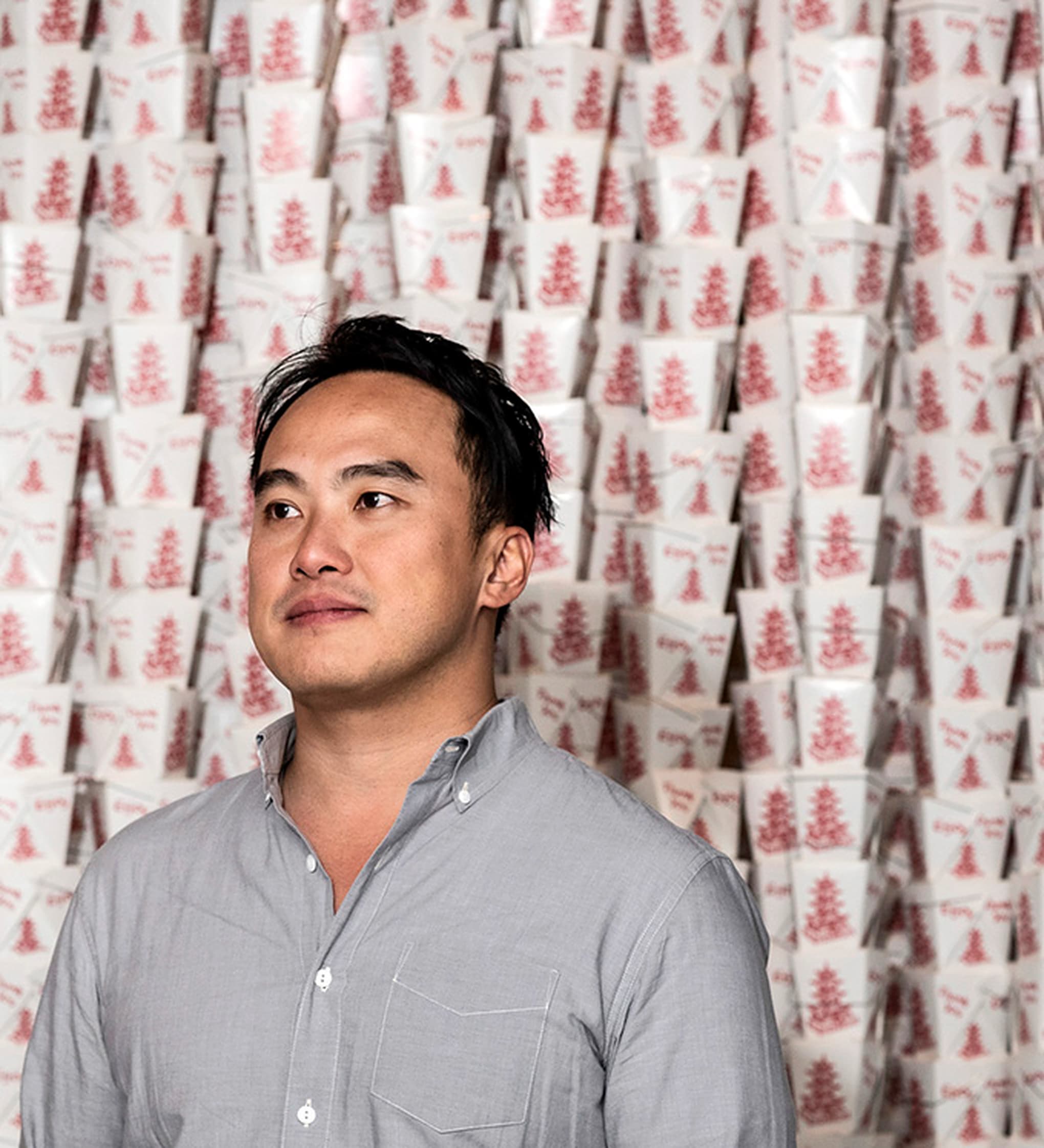 Mike Lee in front of a wall of takeout boxes